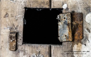 Überwachungsöffnung in einer Zellentür. Von der Klappe ist nur noch das Scharnier vorhanden. Text: © Uta Fischer, All rights reserved